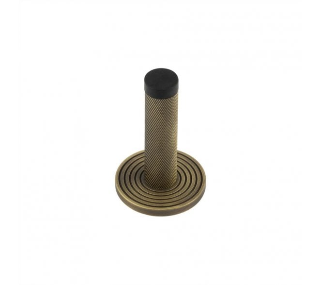 Burlington Knurled Wall Mounted Door Stop On Reeded Rose - Antique Brass